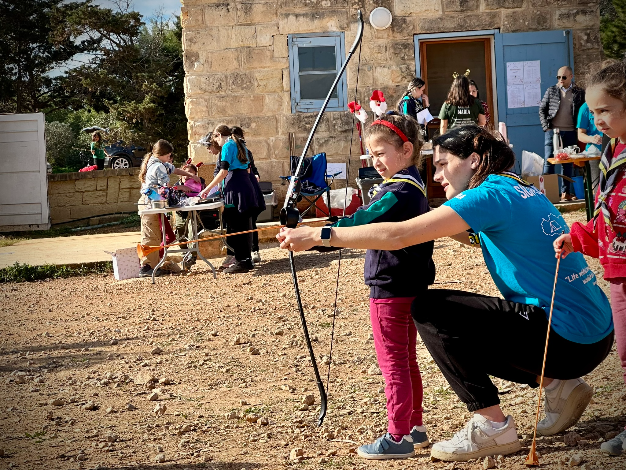 Girls listening to a leader in a wooded area