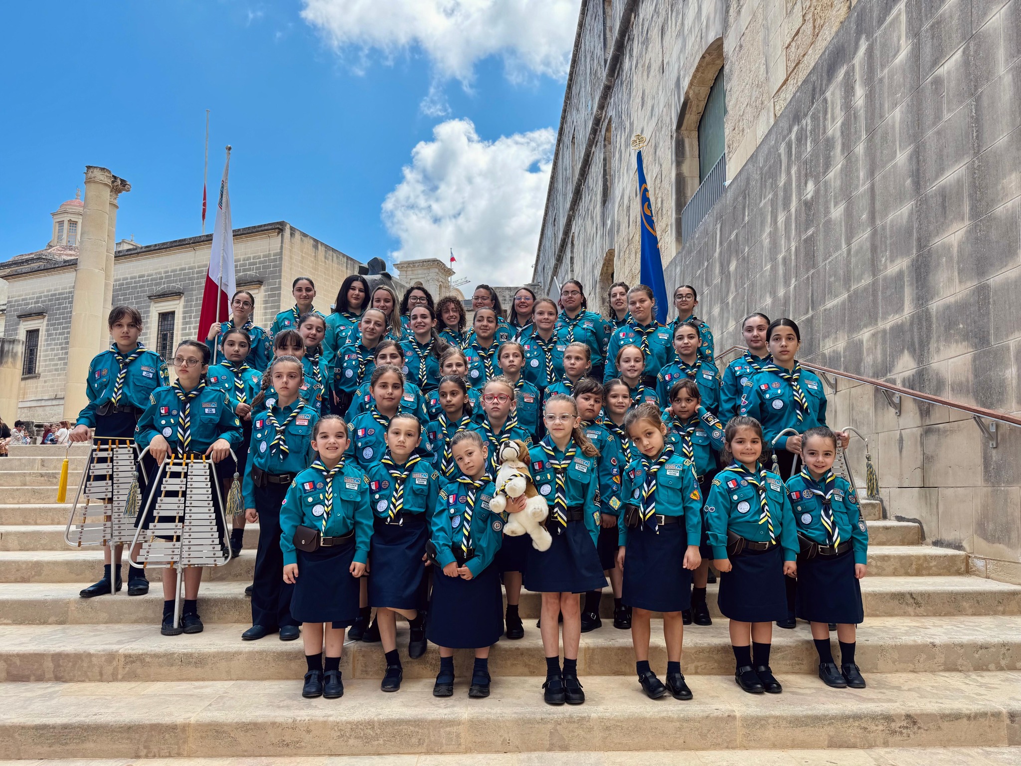 Girl Guides marching together along a Maltese street